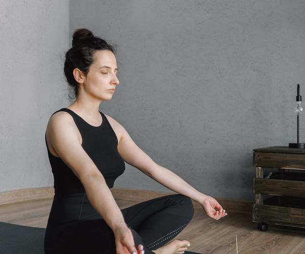 Person meditating in a modern office space, symbolizing mental clarity.